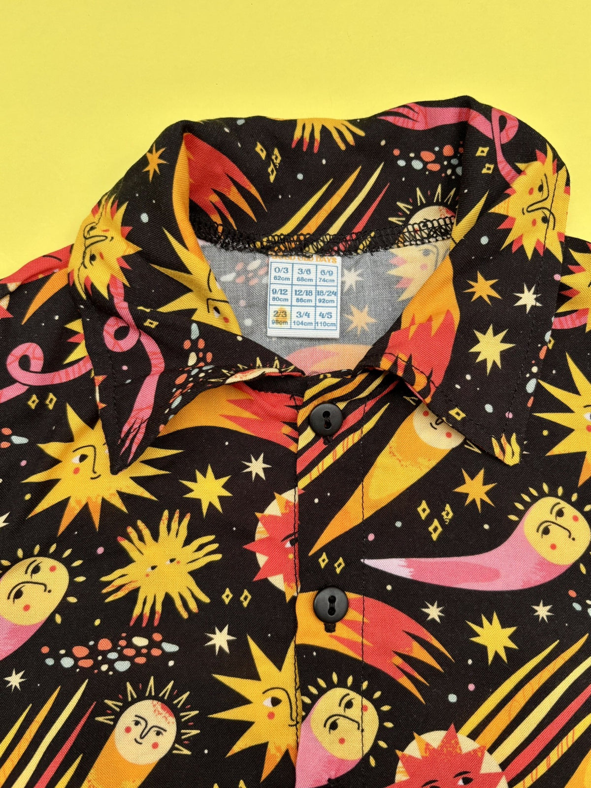 Detalle del estampado de soles, cometas y estrellas de la camisa Cosmos